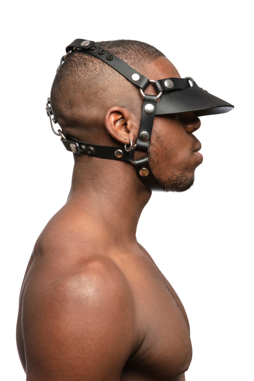  Model wearing black leather head harness and visor with stainless steel hardware. Side view.