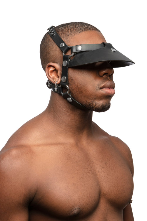  Model wearing black leather head harness and visor with stainless steel hardware.