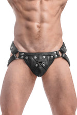Model wearing a black leather harness jockstrap with stainless steel hardware. Front view.