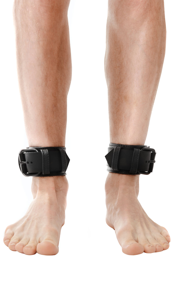 Model wearing black leather ankle restraints