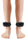 Model wearing grey and black leather ankle restraints