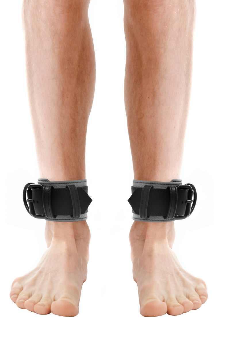 Model wearing grey and black leather ankle restraints