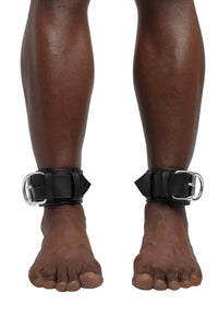 Model wearing black and stainless steel leather ankle restraints
