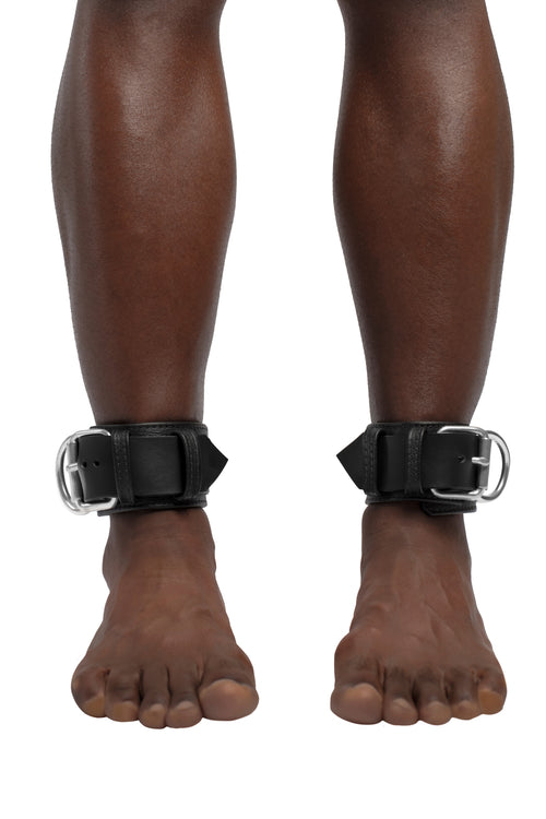 Model wearing black and stainless steel leather ankle restraints