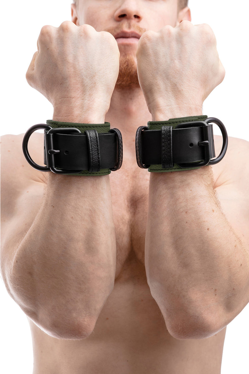Model wearing army green and black leather wrist restraints