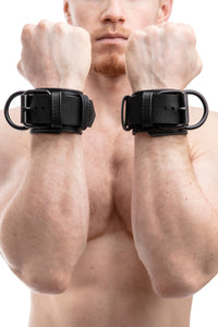 Model wearing black leather wrist restraints