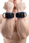 Model wearing blue and black leather wrist restraints