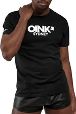 Model wearing black "OINK SYDNEY" t-shirt. Front view.
