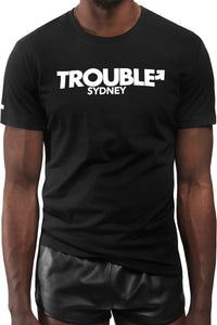 Model wearing black "TROUBLE SYDNEY" t-shirt. Front view.