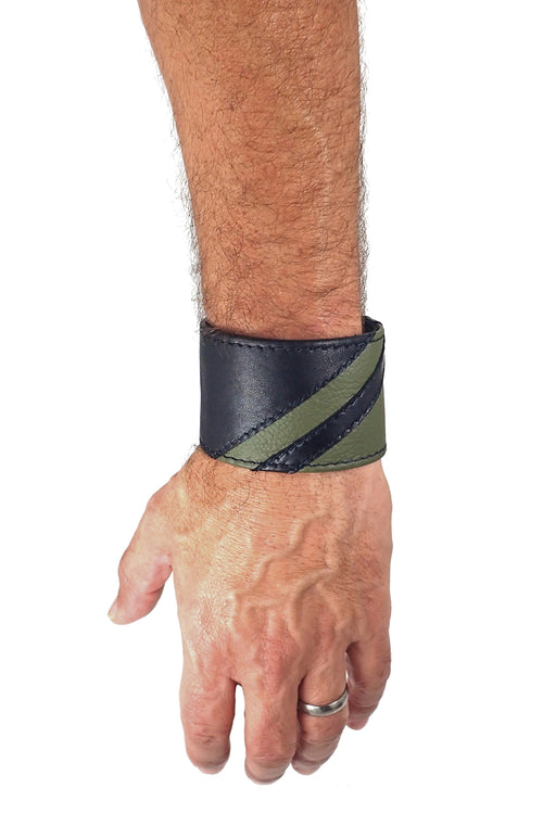Model wearing a black leather wristband with army green leather chevron detailing. Left Wrist.