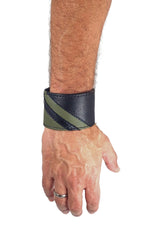 Model wearing a black leather wristband with army green leather chevron detailing. Right Wrist.