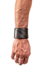 Model wearing a black leather wristband with black leather chevron detailing. Right Wrist.