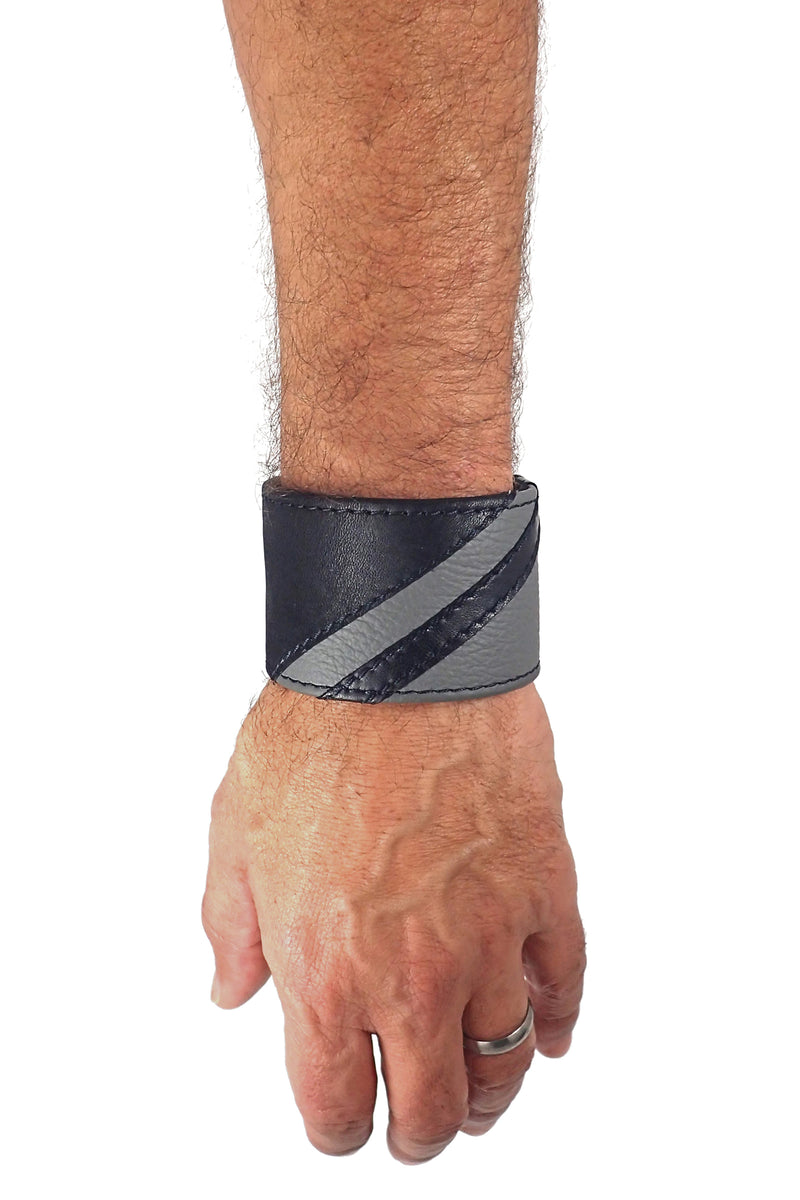 Model wearing a black leather wristband with grey leather chevron detailing. Left Wrist.