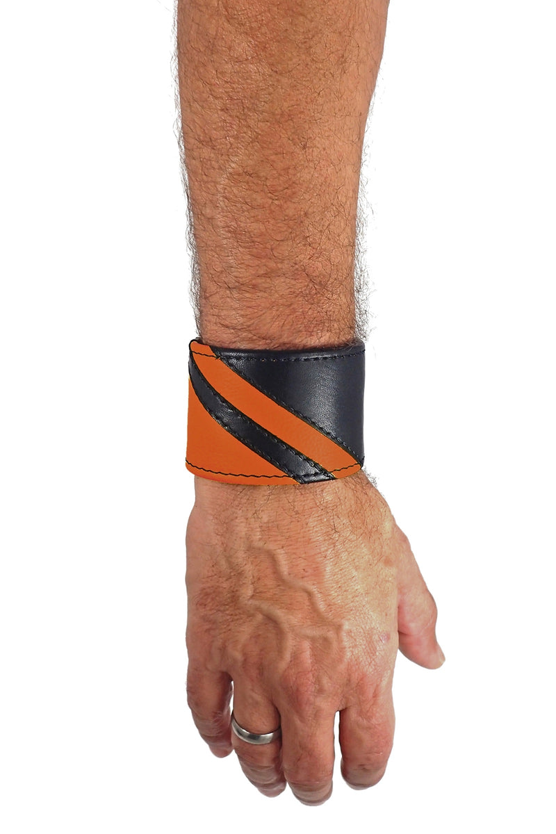 Model wearing a black leather wristband with orange leather chevron detailing. Right Wrist.