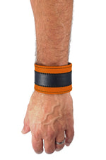 Model wearing a 2" wide leather wristband with orange leather racer stripe detailing